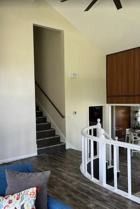This is an image from CertaPro Painters of Shawnee Mission, KS.The image is an interior stairway area in Shawnee Mission KS with freshly painted light beige walls and dark wood flooring.