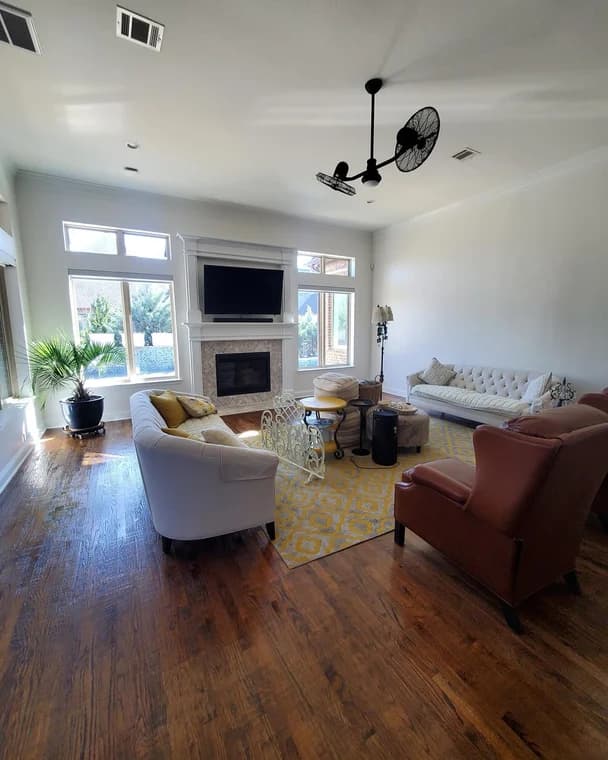This is an image from Alliance Painting, located in Texas. The living room showcases newly painted walls in a light color, highlighting the natural light and complementing the hardwood floors.