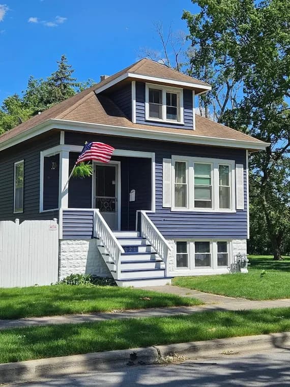 Exterior painting by Artisons Painting in Brookfield, IL. The image shows a blue-gray home with white trim and steps.