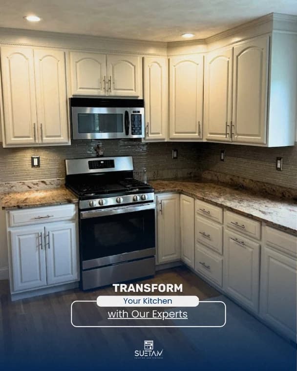 This is an image from Suetam Painting & Finishes. It showcases a modern kitchen with freshly painted cream cabinets, granite countertops, and stainless steel appliances, emphasizing a clean and updated look.