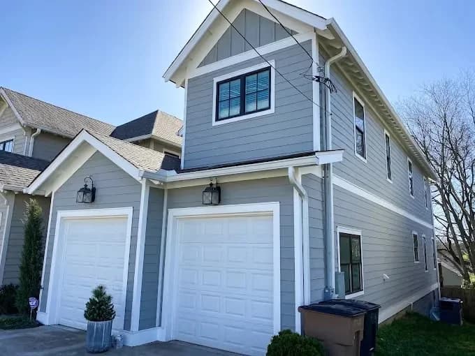 Marlin Painting and Remodeling painting project in Brentwood, Tennessee. The image shows a blue-gray garage addition with white doors.