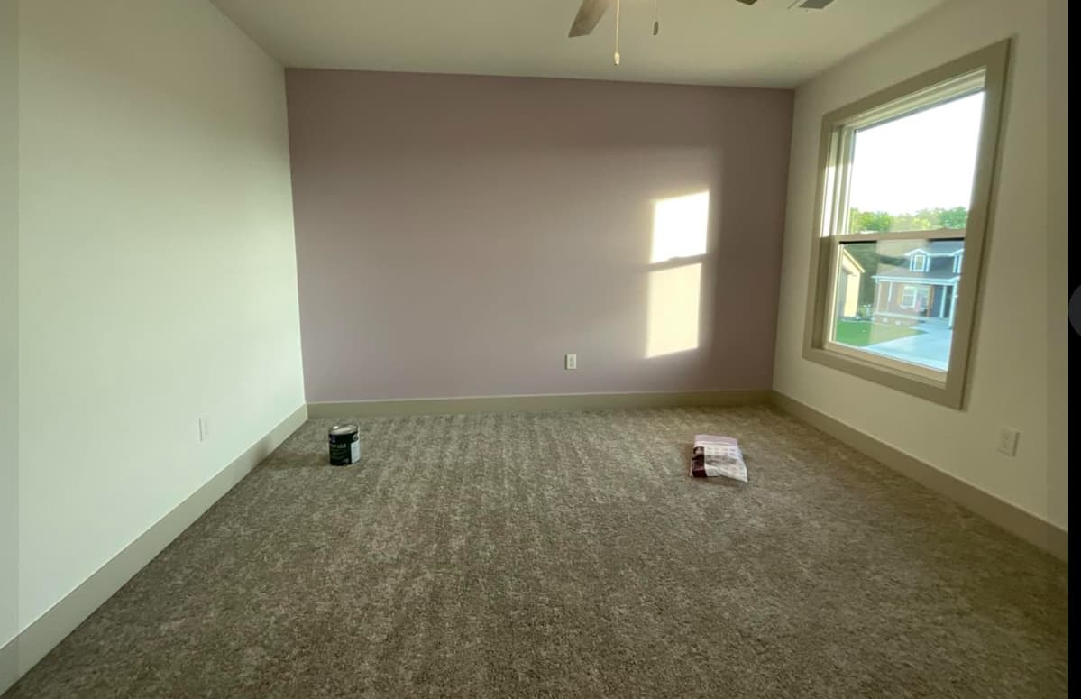 This is an image from Painter's Painting. The image is a Bedroom in Kansas home with light purple accent wall, white side walls, and freshly painted trim.