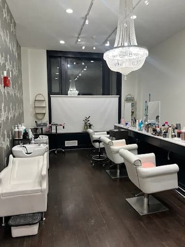 This is an image from BEE Pro Painting, located in New Jersey. The image shows a newly painted commercial salon interior with white walls, dark flooring, modern lighting fixtures, and styling stations arranged throughout the space.