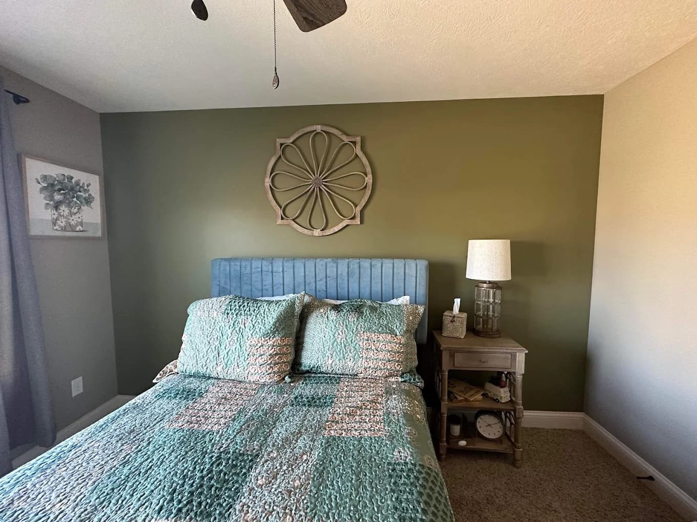 Interior painting project by Total Coverage Painting in Bloomington, Illinois. The image shows an olive green bedroom accent wall, gray side walls, and coordinated furnishings.