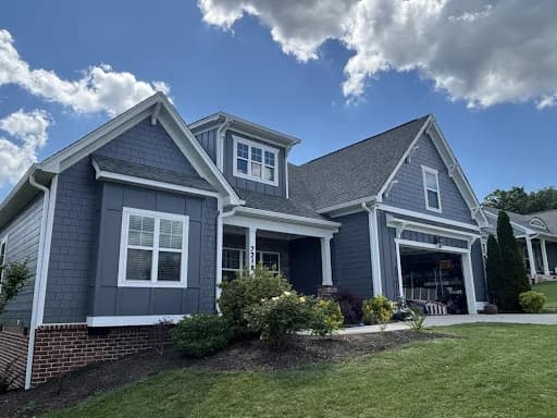 Ridgeline Pro Painters painting project in Chattanooga, Tennessee. The image shows a blue-gray home with white trim and garage doors.