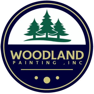 This is an image from Woodland Painting, Inc, located in Minnesota. The logo for Woodland Painting, Inc features three green pine trees inside a circular navy and gold emblem with the company name in bold lettering.