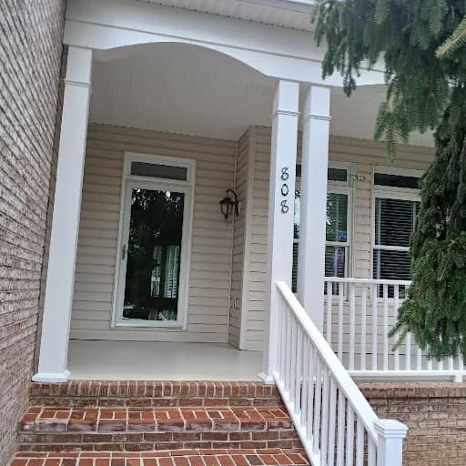 Painting work by Pilgrim Painting in Knoxville, Tennessee. The image shows a beige front porch with white columns.