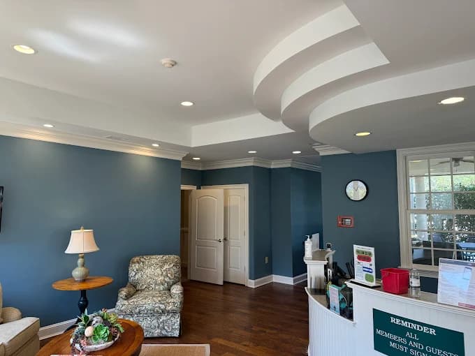Interior painting project by 360° Painting of Pinehurst in Southern Pines, NC. The image shows blue bedroom walls, a curved ceiling detail, bed, and windows.