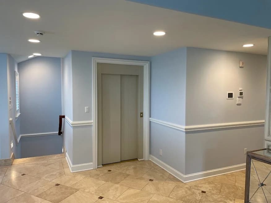 Hallway and elevator area painted by Brush Masters Painting Contractors LLC in Egg Harbor Township, New Jersey, featuring light blue walls with white trim.