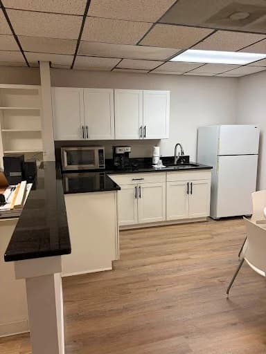Painting work by Scott Brown Professional Painting & Remodeling in Chattanooga, Tennessee. The image shows a white commercial kitchenette with dark counters.