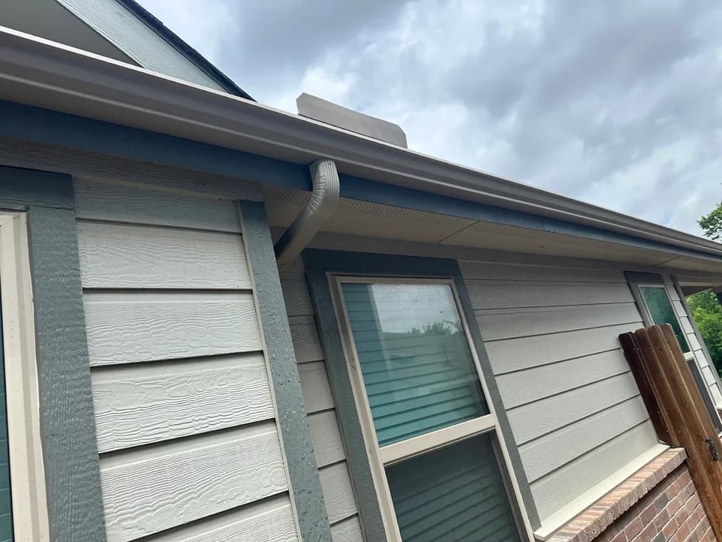 "This is an image from L&D Painting & Remodeling, located in Texas. The photo shows newly painted exterior siding and gutters on a residential home, highlighting clean trim work around the windows."