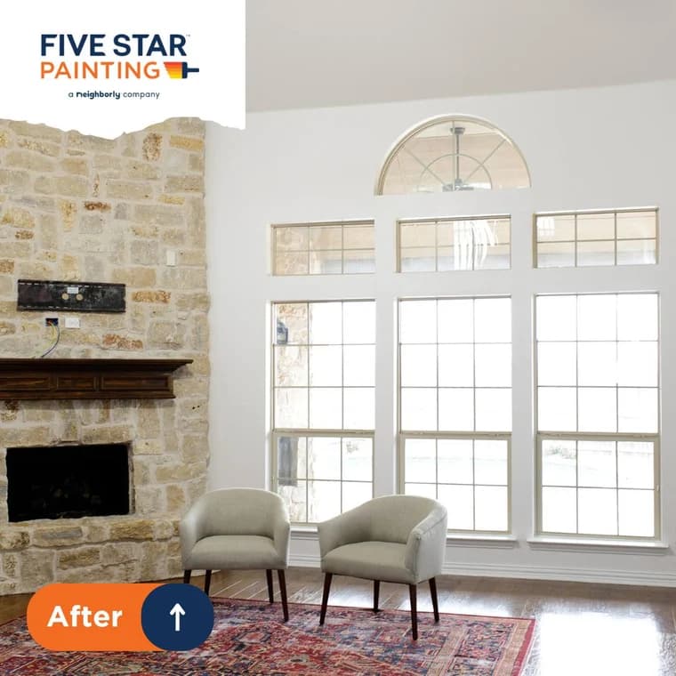 This is an image from Five Star Painting of White Plains, located in New York. The interior photo shows a bright living space with white walls, a stone fireplace, large windows, and two light-colored chairs on a patterned rug.