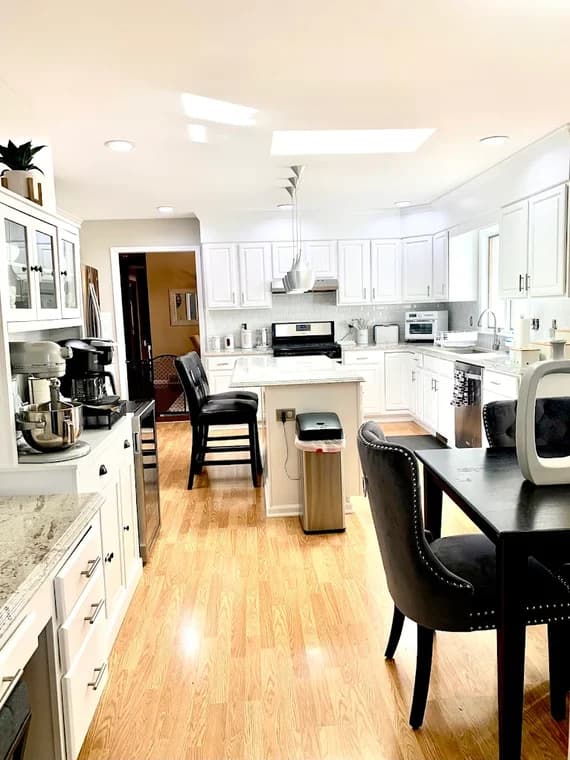 This is an image from Braun's Painting, LLC, located in New York. The photo displays a bright white kitchen with updated cabinets, light countertops, and wood flooring.