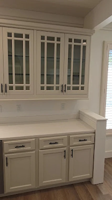 Cabinet painting project by Buchanan Painting in Hendersonville, NC. The image shows white built-in cabinets with glass doors, drawers, and hardware.