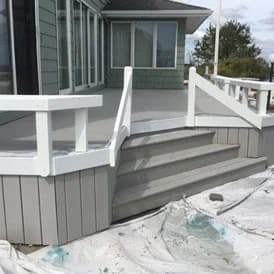 Painted deck project by Array of Color Painting LLC, highlighting a gray floor with crisp white railings for a clean and updated look.