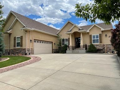 Exterior painting by All Painting Plus 2, LLC in Colorado Springs, Colorado. The image shows tan walls around a garage.
