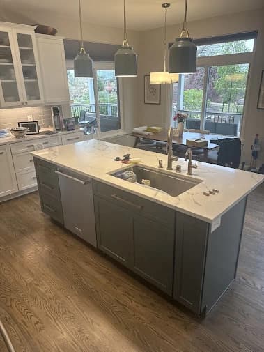 Cabinet painting by Brush Brothers Painting LLP in Golden, Colorado. The image shows a gray island below white cabinets.