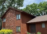 Exterior painting by Brush Brothers Painting LLP in Golden, Colorado. The image shows red wood siding on a small house.