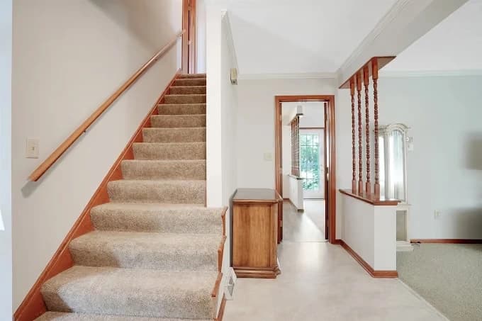 Interior painting by 360 Painting of Columbus in Reynoldsburg, Ohio. The image shows pale walls beside carpeted stairs and wood rails.