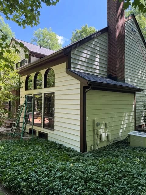 Exterior painting by Skye Painting Llc in Ohio. The image shows green siding beside a tall brick chimney.