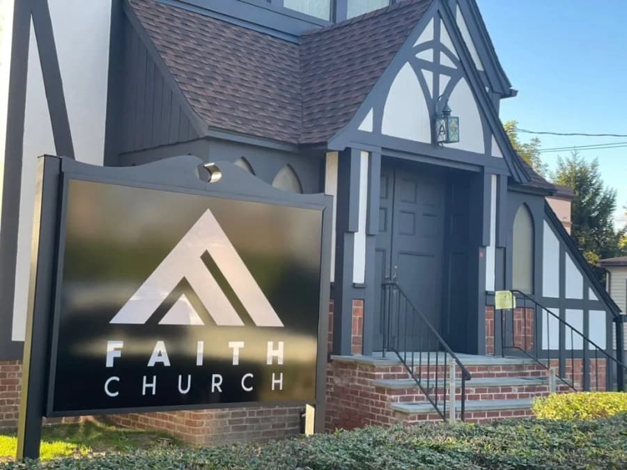This is an image from Azul Painting Corp, located in New Jersey. The image shows a freshly painted church exterior with Tudor-style architectural details and a branded Faith Church sign in the foreground.