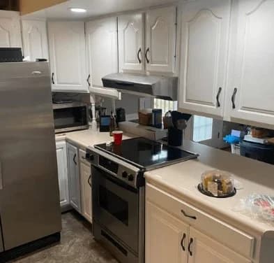 This is an image from 360 Painting of Wichita. The image shows a kitchen with freshly painted white cabinets, giving the space a bright and clean finish.