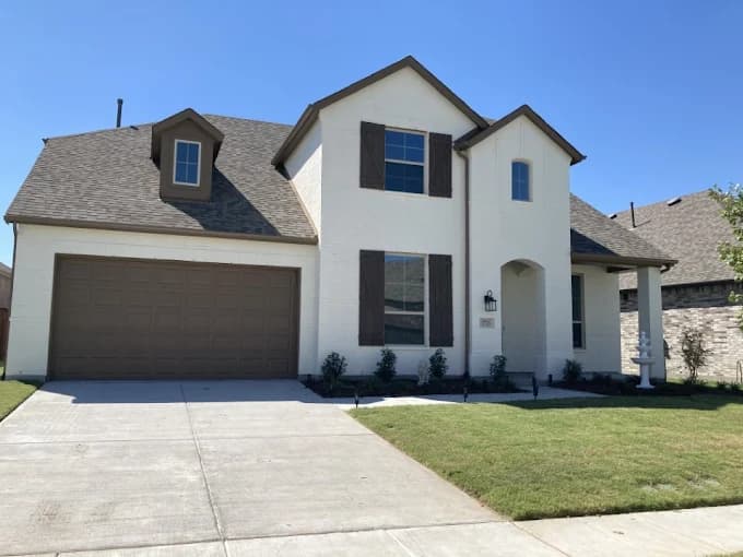 This is an image from Spray-Net Lexington, located in Kentucky. The image shows a freshly painted white brick home exterior with dark shutters and a clean, modern curb appeal finish.