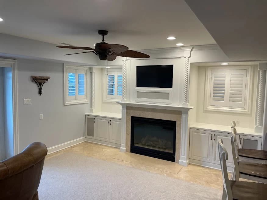 Interior living room painted by Brush Masters Painting Contractors LLC in Egg Harbor Township, New Jersey, showing a fireplace with built-in shelving and soft gray walls.