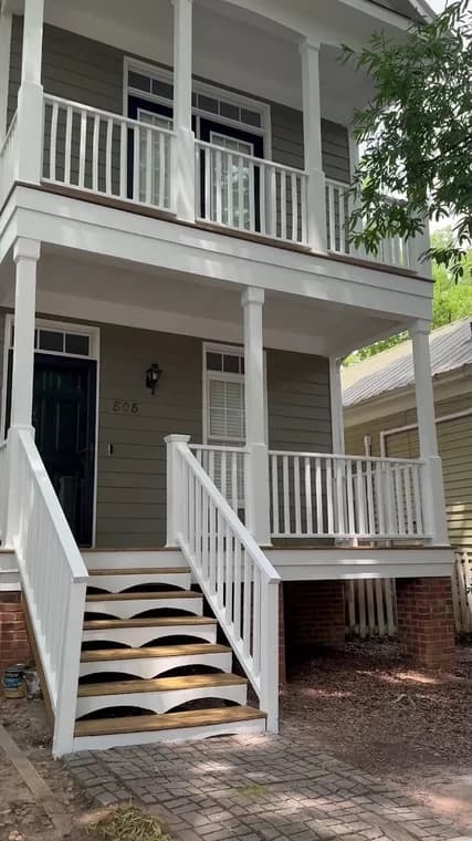 Exterior trim painting project by CPM Painting INC in Raleigh, NC. The image shows white porch railings, columns, stairs, and gray siding.
