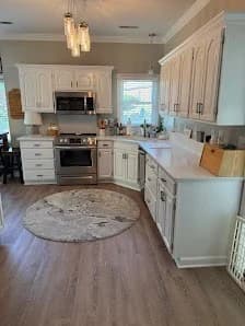 Cabinet painting project by 360° Painting of Winston-Salem in Winston-Salem, NC. The image shows white cabinets, gray walls, a range, and light flooring.