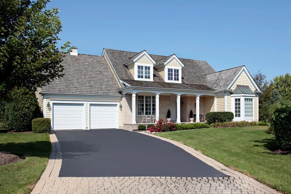This is an image from Goode Design Painting & Wallcovering Inc., located in Virginia. The exterior photo shows a beautifully maintained suburban home with light yellow siding, white trim, and a freshly paved driveway.