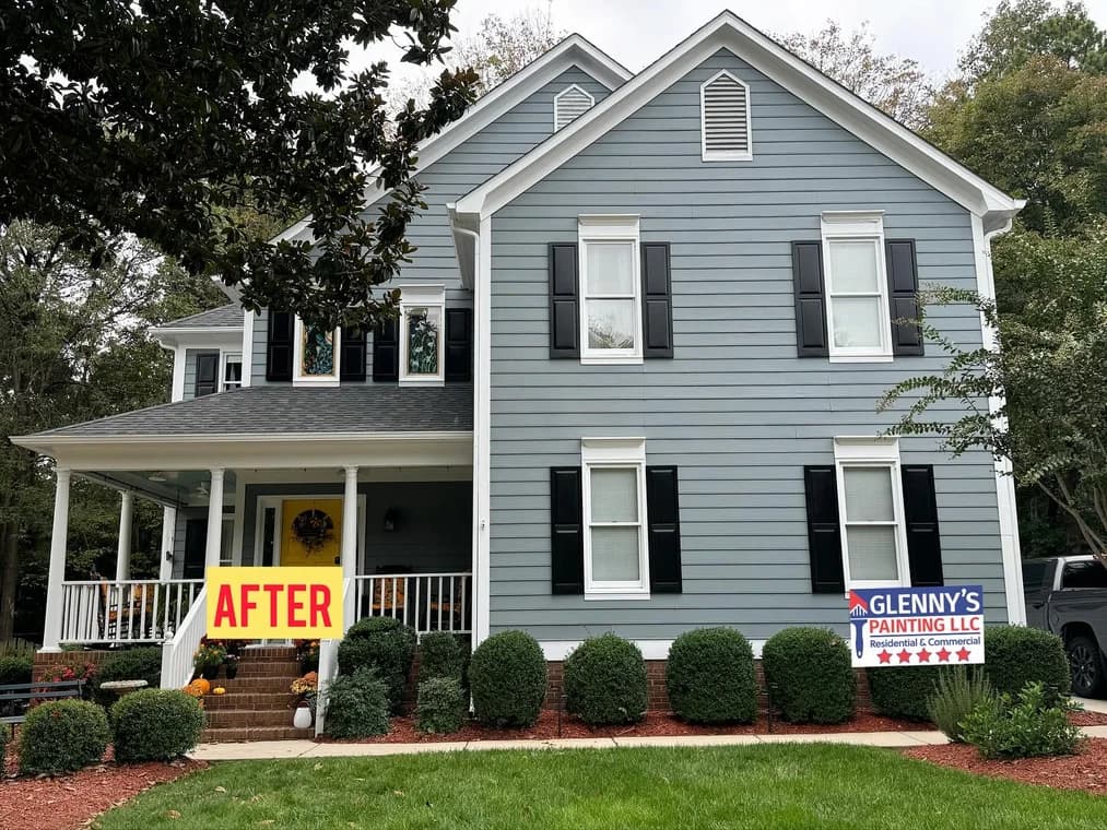 Exterior painting project by Glenny's Painting LLC in Charlotte, NC. The image shows a light blue two-story home with white trim and black shutters.