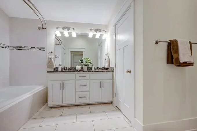 Painting project by Premier Painting Company in Smyrna, Tennessee. The image shows a white bathroom with dark fixtures.