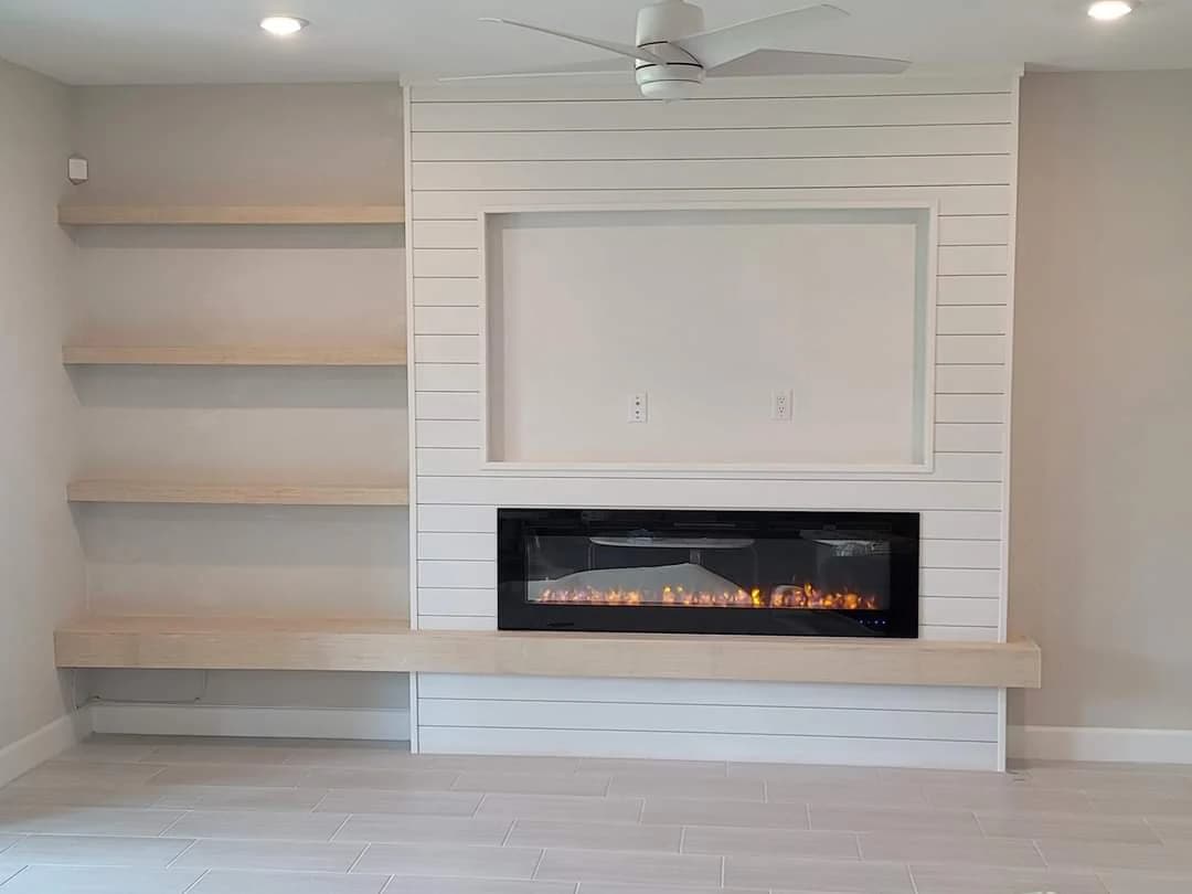 Interior painting project by Paint Guru House Painters in Highland Park, Illinois. The image shows a white shiplap fireplace, built-in shelves, and light wood accents.