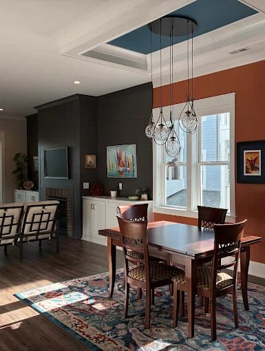 Interior painting project by Anderson Painting in Raleigh, North Carolina. The image shows a dining room, dark wall, pendant light, and tray ceiling.
