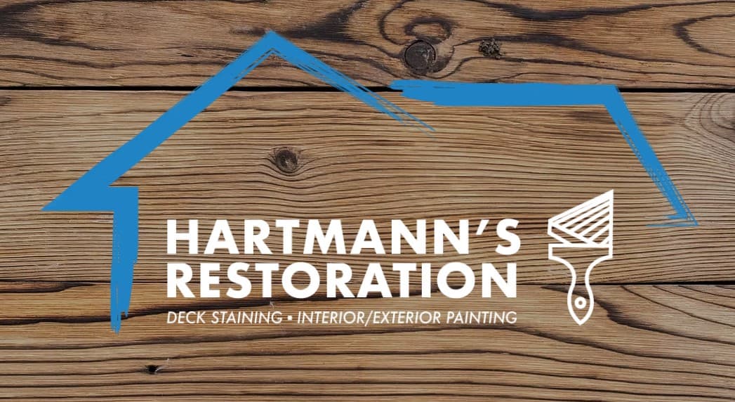 This is an image from Hartmann’s Restoration LLC, located in Minnesota. The logo for Hartmann’s Restoration LLC features white bold lettering over a wood plank background with a blue house outline and a paintbrush graphic.