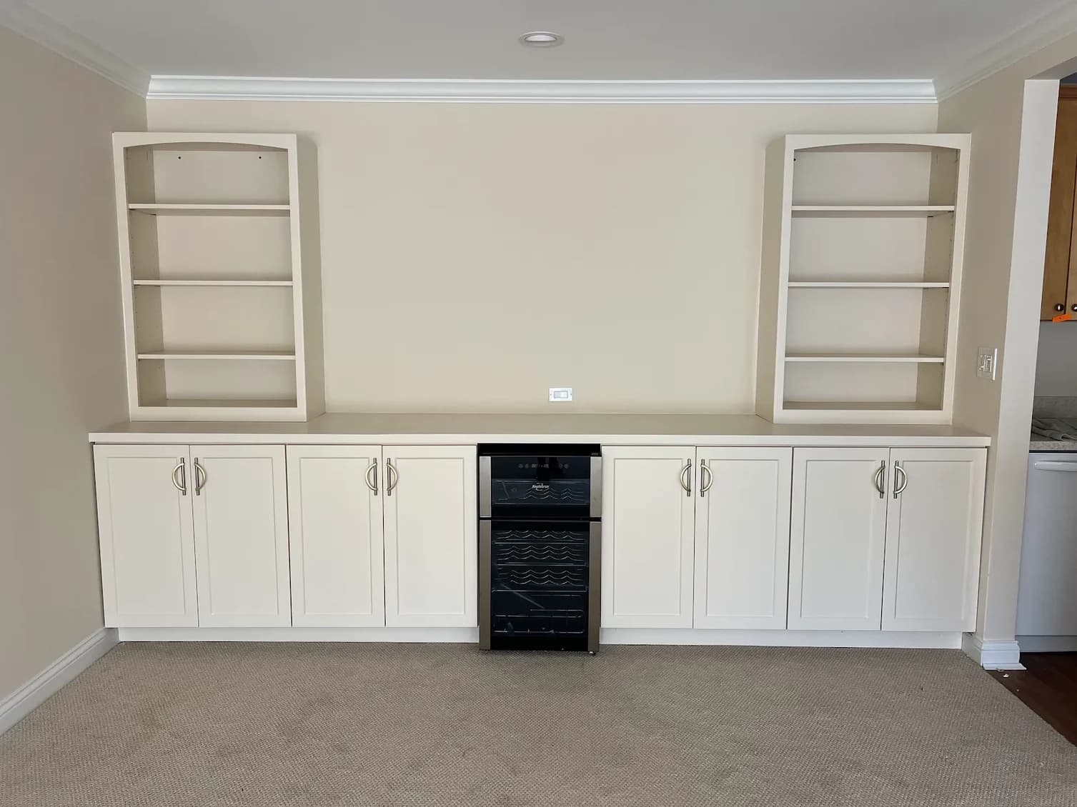 Cabinet painting by Joyful Cabinet Painting in Cincinnati, Ohio. The image shows white built-ins around a small refrigerator.
