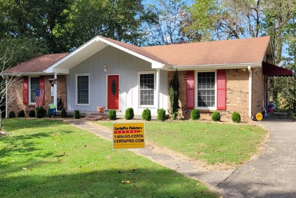 Single-story home with a gray exterior and red door painted by CertaPro Painters of Clarksville, Tennessee and Hopkinsville, Kentucky.