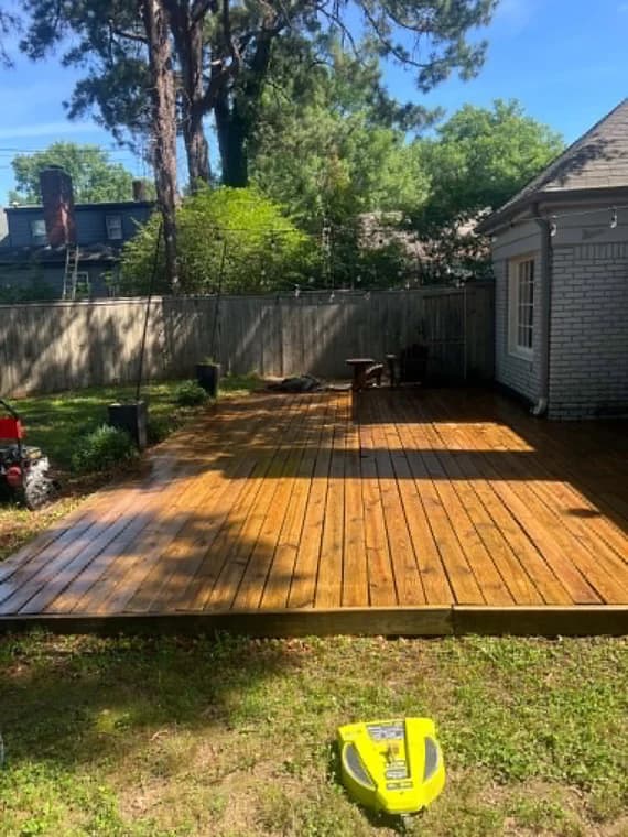 Painting project by Healthy Home Pros in Millington, Tennessee. The image shows a stained wood deck beside a fenced yard.