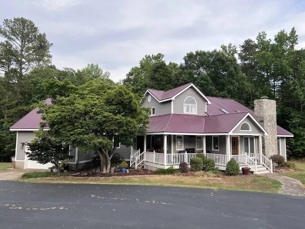 Exterior painting project by Dr. Lopez Painting LLC in Durham, NC. The image shows a pink two-story home with white trim, trees, and a front porch.