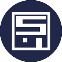 This is the logo of Suetam Painting & Finishes. The design features a bold geometric emblem with stylized white lettering inside a navy circle, incorporating the outline of a house with a window, symbolizing their expertise in painting and finishing services.