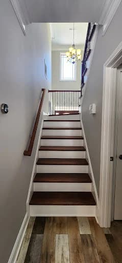Painting project by Randy the Painter & Crew in Knoxville, Tennessee. The image shows a gray stairwell with white trim and dark steps.