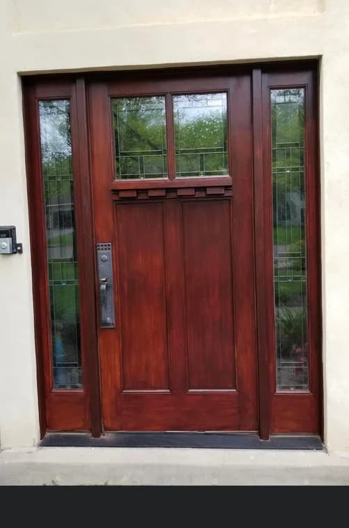 This is an image from Disbrow Painting And Handyman Services Company company, located in Levittown, PA. The image is a recently stained or painted dark wood entry door with decorative glass panels.