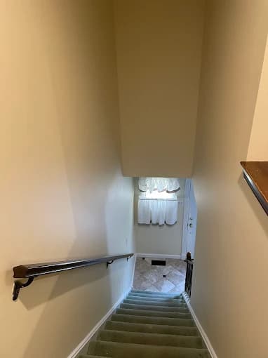 This is an image from T Whitaker Painting in New Jersey. It depicts a stairwell painted in warm beige tones, showcasing the company’s interior work.