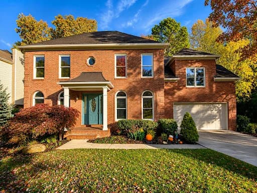 Painting work by McLain's Painting in Knoxville, Tennessee. The image shows a two-story brick home with painted entry trim.