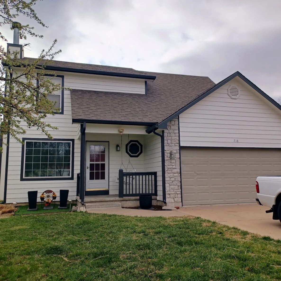 This is an image from Paint Pro Inc. The image is exterior house painting in Kansas City KS with freshly painted white siding and dark trim.