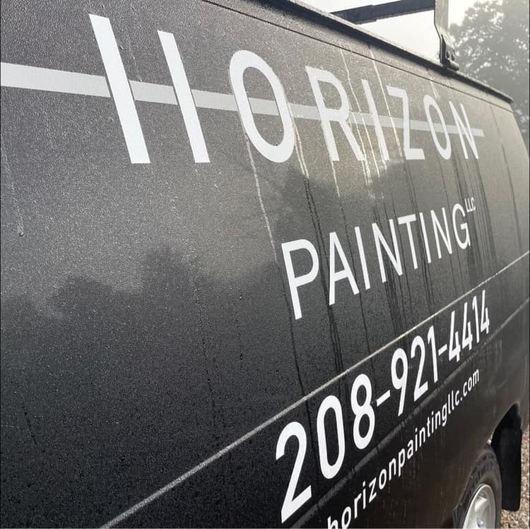 This is an image from Horizon Painting LLC company, located in Boise, ID The image is a Horizon Painting LLC branded black service van with company name, phone number 208-921-4414, and website horizonpaintingllc.com in white vinyl lettering