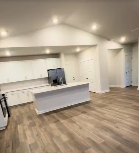 Covenant Painting Services painting project in Gallatin, Tennessee. The image shows an open white kitchen and living area with wood-look floors.