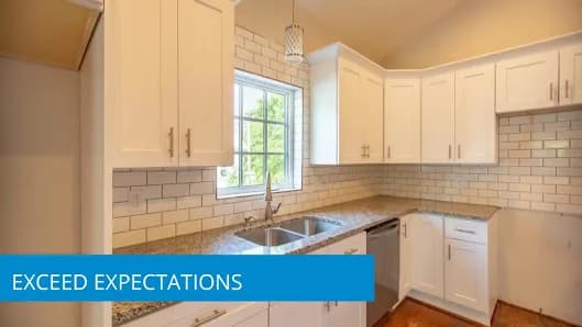 Kitchen painting project by Zarazua Painting in Durham, North Carolina. The image shows white cabinets, a tile backsplash, a window, and light counters.