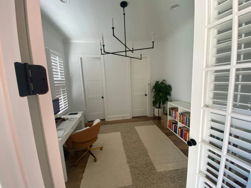 This is an image fromNash Painting Company, located in Tennessee. The image is a home office with white walls, French doors, and minimalist decor freshly painted by Nash Painting Company.